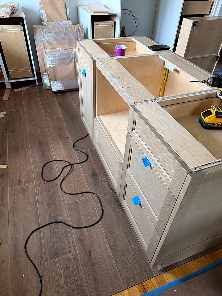 Island base cabinets set in place on the new plank floor