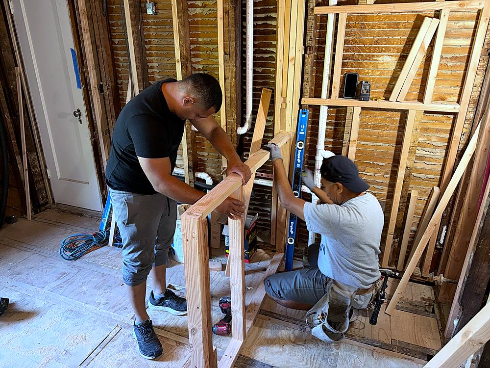 Two crew members framing the new bathroom walls