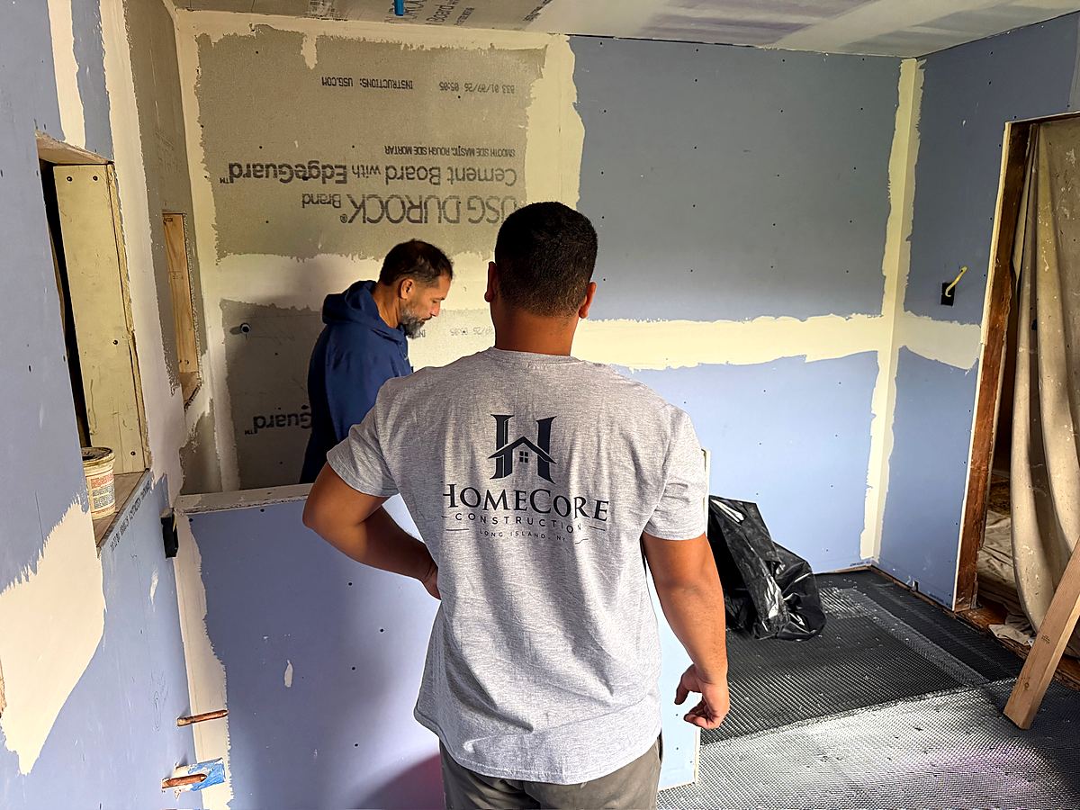 Crew member hanging waterproof board in the bathroom