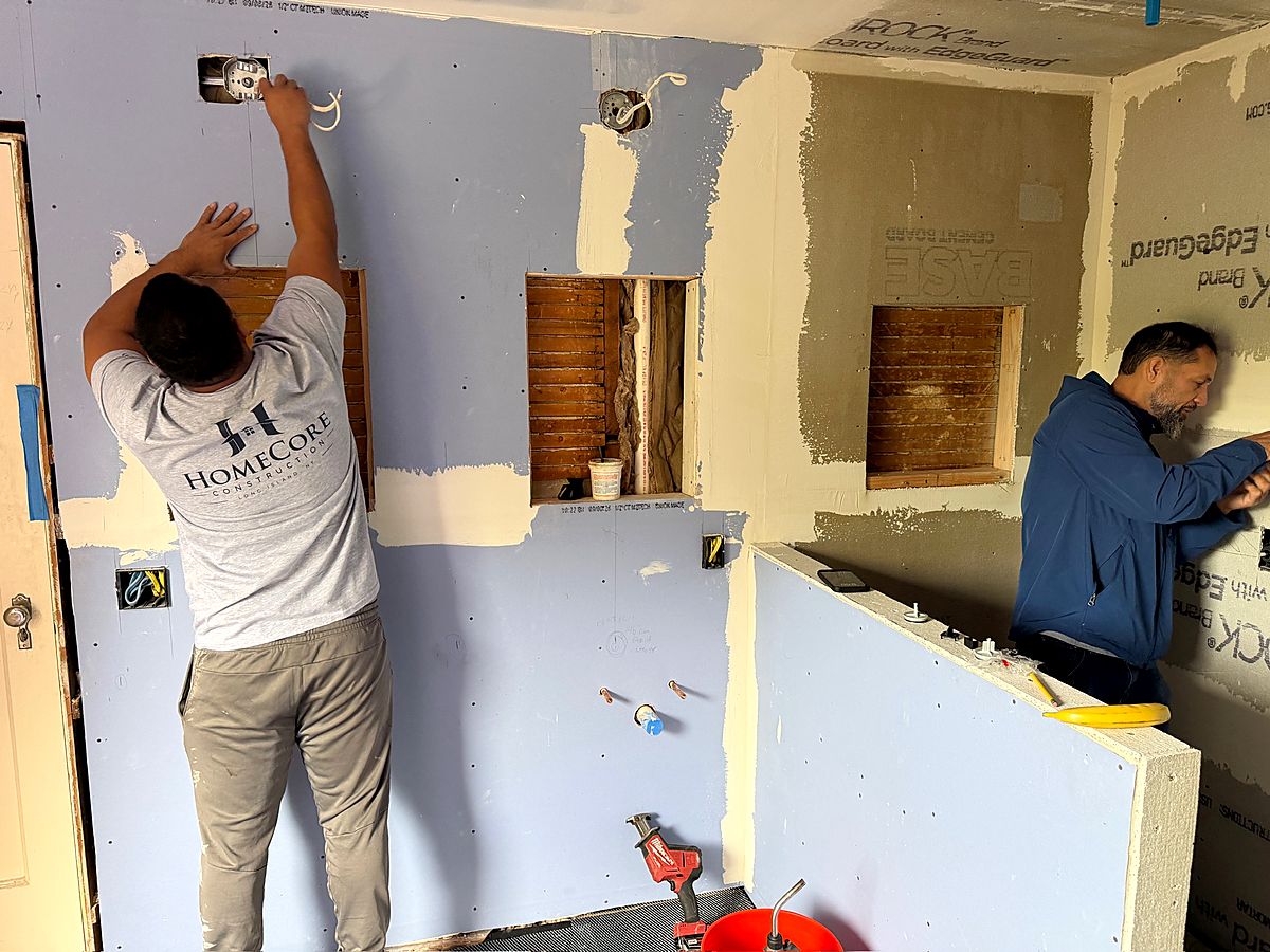 Crew installing waterproof board around the new vanity wall