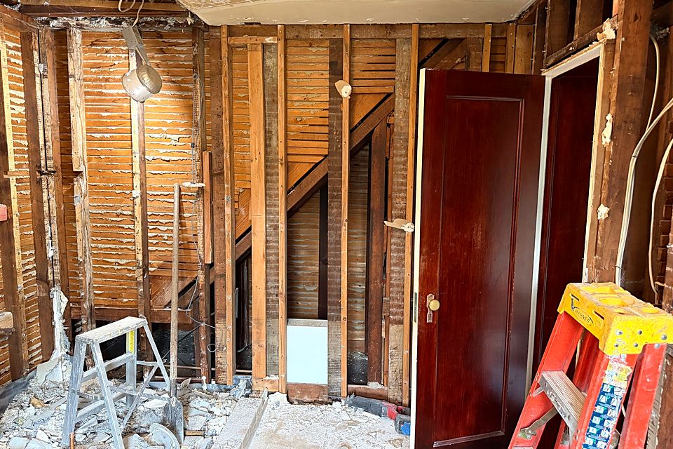 Bath and closet area gutted to the studs with the old door still hung