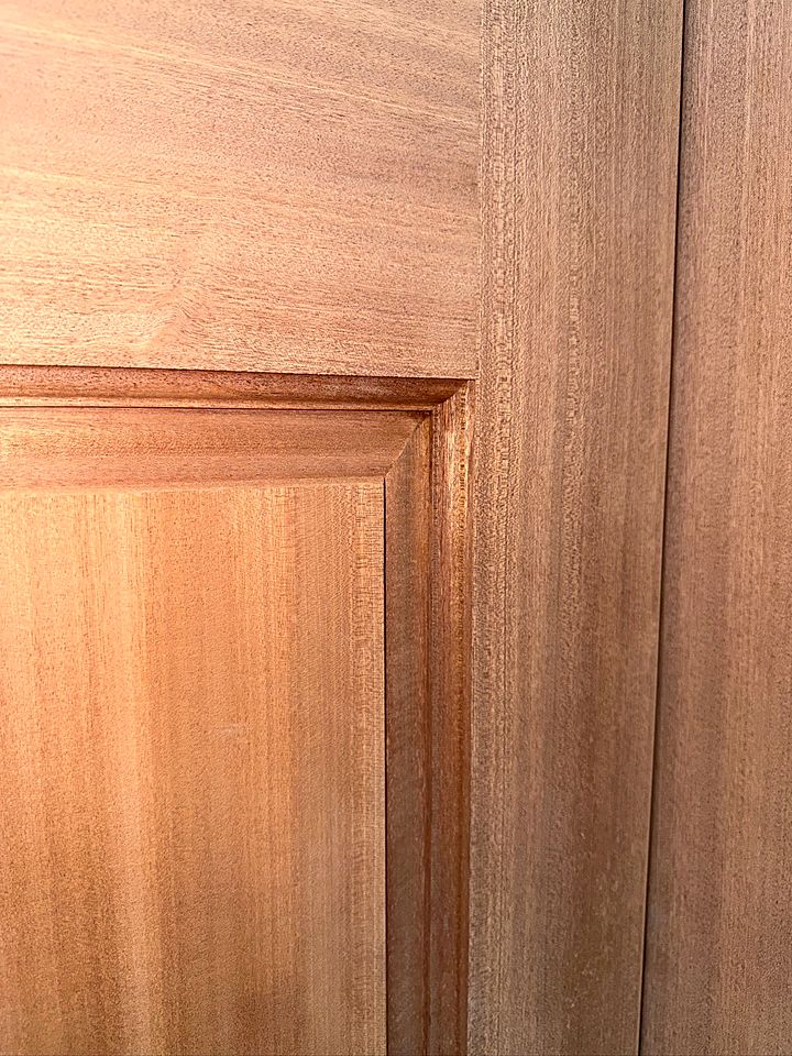 Close view of the raised panel and molded edge on a mahogany door