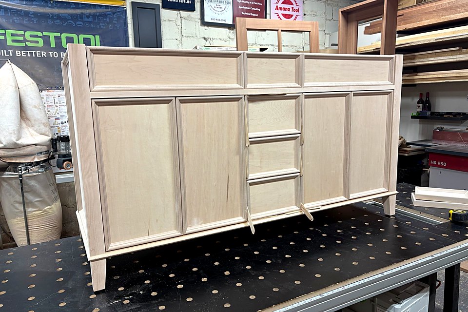 Custom vanity with drawers and doors in raw wood on the shop bench