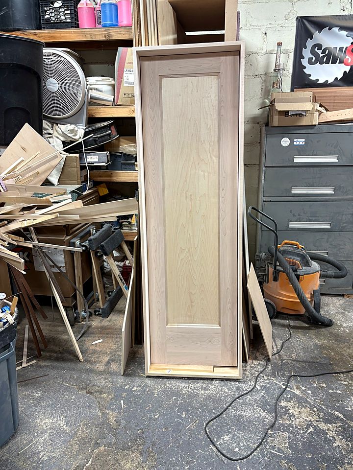 Tall paneled door standing in the shop after assembly