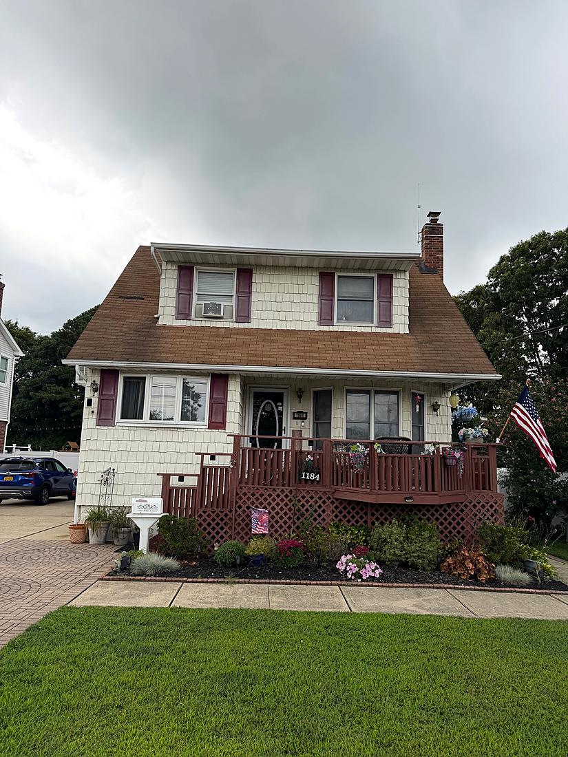 Cape style home with the original front stoop before the porch build