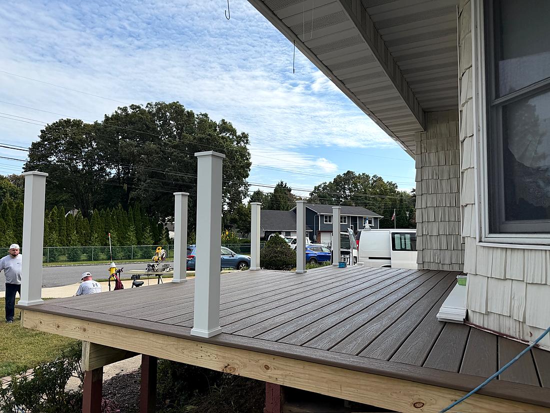 Finished front porch with white columns and composite decking