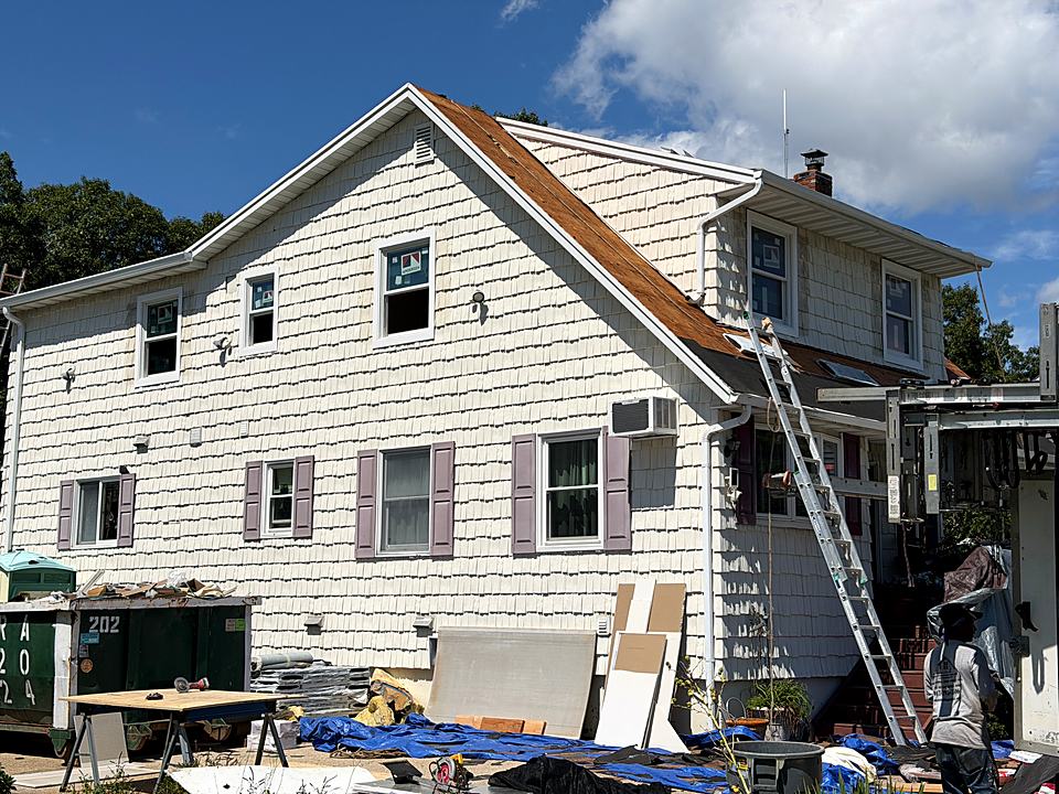 House exterior during a roof replacement with the old roofing stripped to the deck