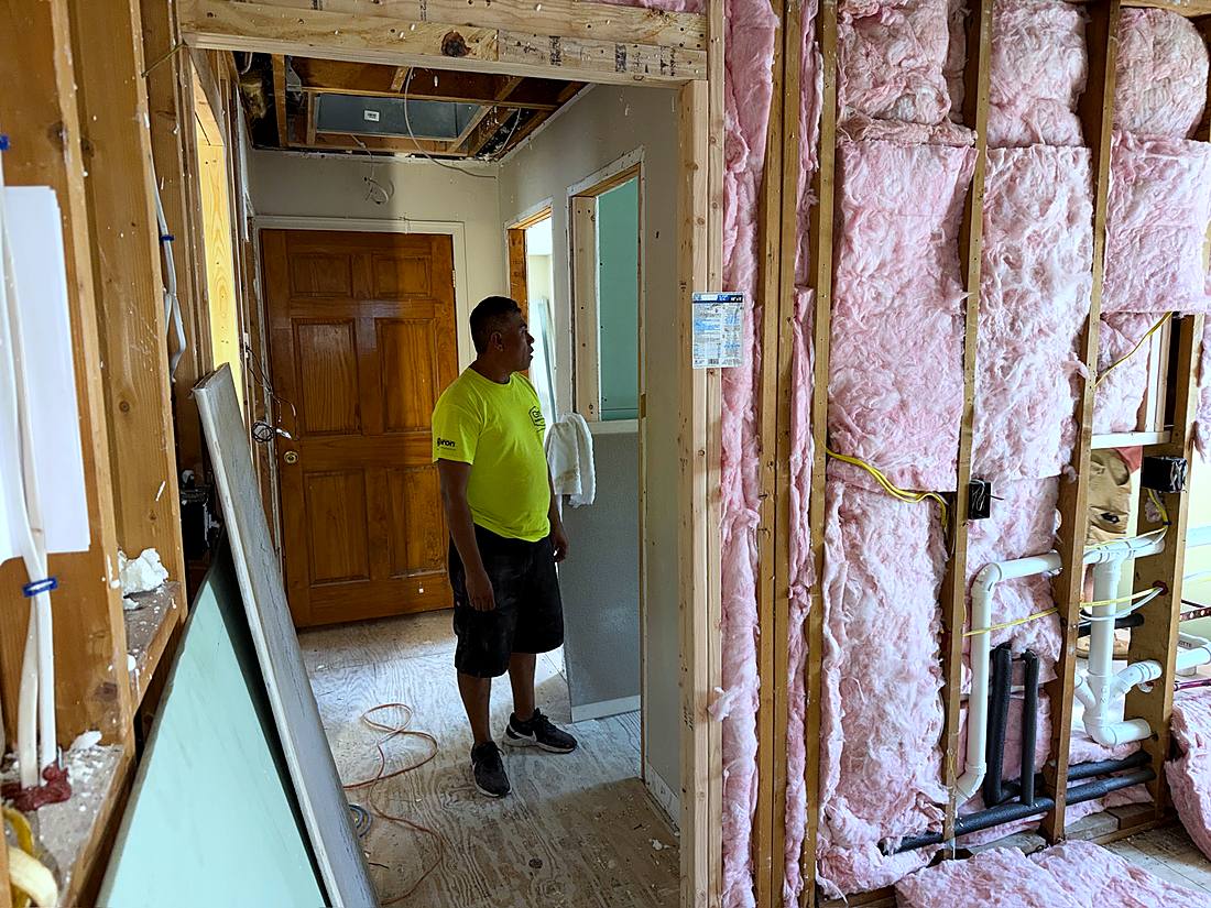 Crew member working in the framed doorway during the gut renovation
