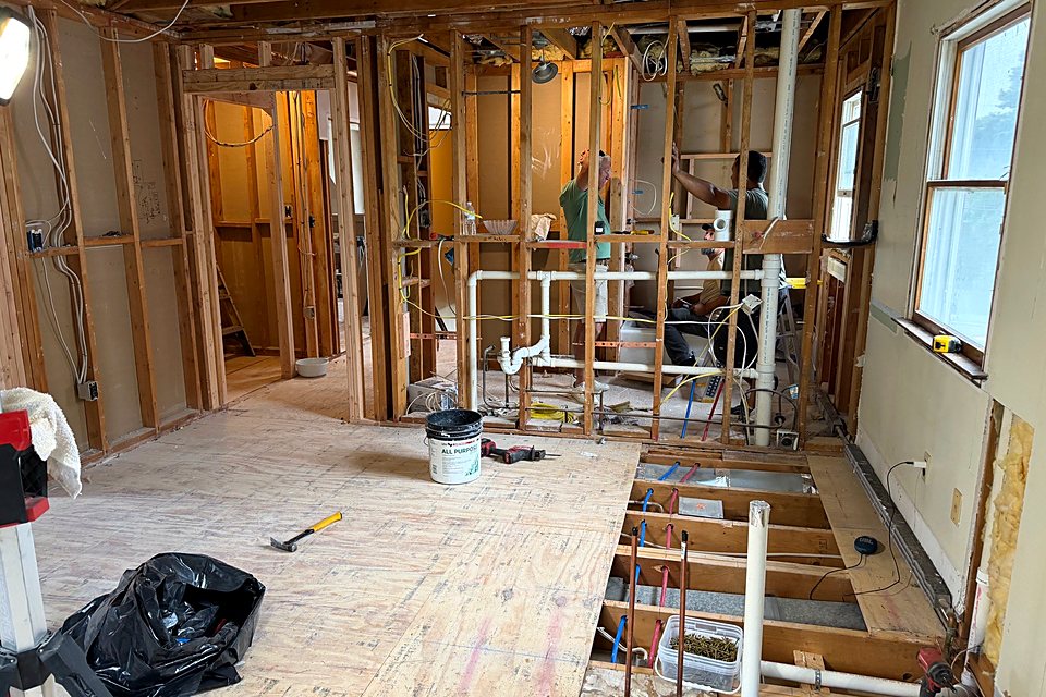 Wide view of the gutted floor with new plumbing roughed in through the joists