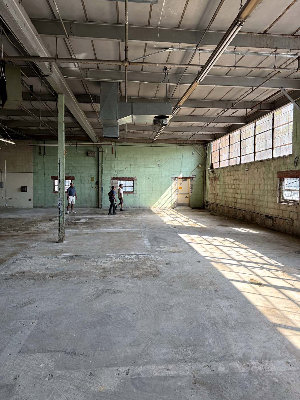 The full length of the stripped space with daylight coming through the window wall