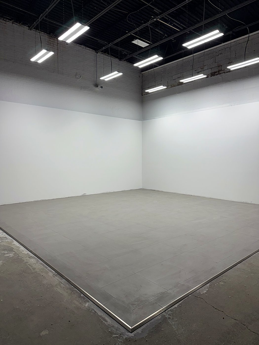 The finished showroom walls painted white with new lighting installed overhead