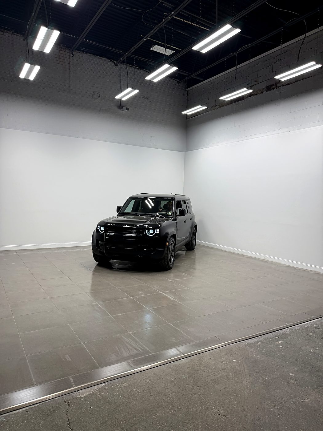 The completed showroom with large-format porcelain tile flooring and a vehicle on display