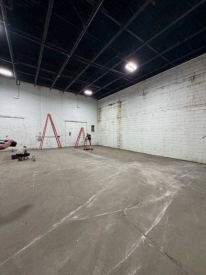 Bright white showroom walls with a ladder set up for the final touches